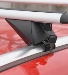 střešní nosiče Compass integrované podelníky na červené střeše auta a zasunutým klíčem